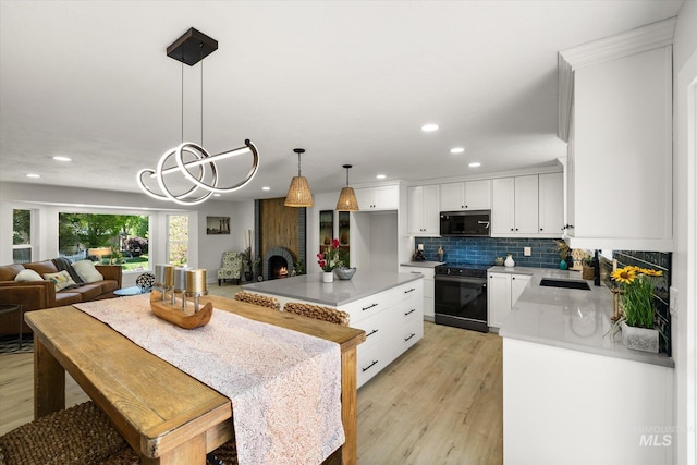 kitchen featuring electric range oven, recessed lighting, light wood finished floors, backsplash, and white cabinetry