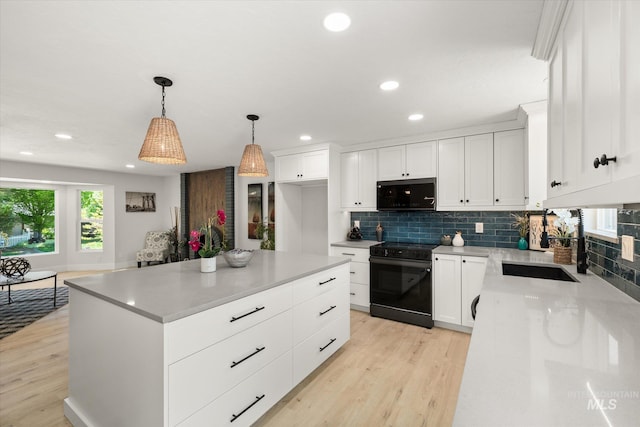 kitchen featuring black appliances, light wood-style floors, recessed lighting, and backsplash