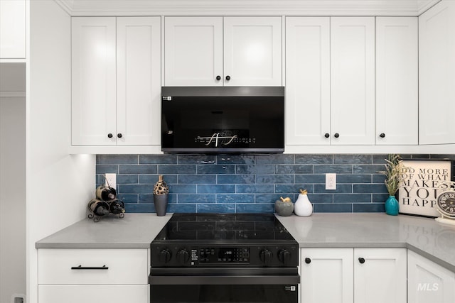 kitchen featuring black electric range oven, white cabinetry, light countertops, and decorative backsplash