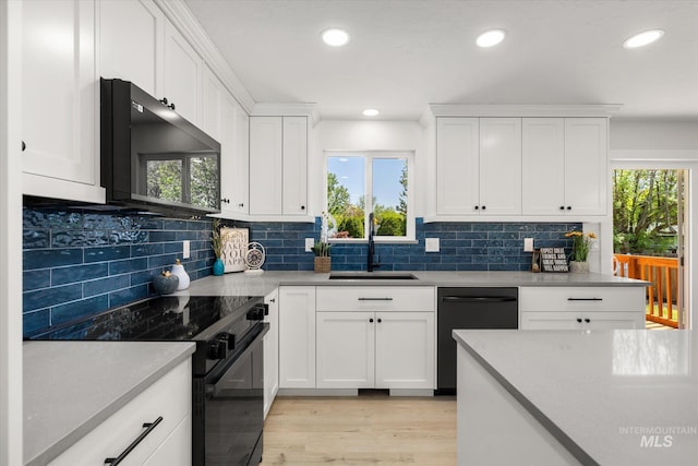 kitchen with black appliances, a sink, healthy amount of natural light, light wood-style flooring, and recessed lighting
