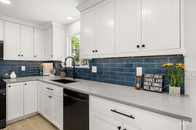 kitchen featuring a sink, black appliances, white cabinetry, backsplash, and recessed lighting