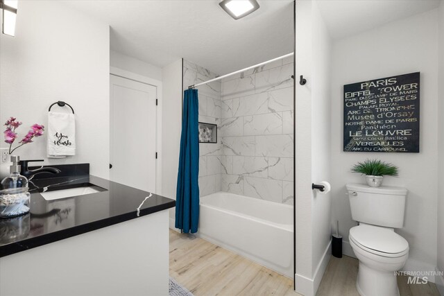bathroom featuring a sink, wood finished floors, shower / bath combination with curtain, baseboards, and toilet