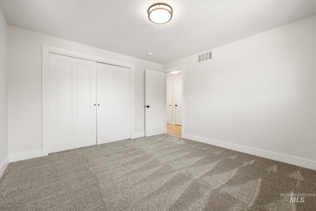 unfurnished bedroom with carpet floors, baseboards, and a closet