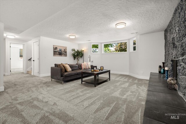 carpeted living room with baseboards and a textured ceiling