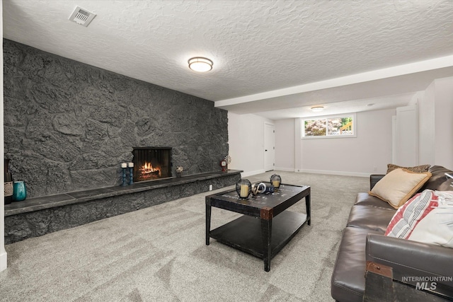 living room featuring carpet floors, a textured ceiling, a stone fireplace, and baseboards