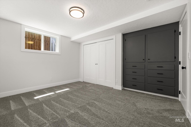 unfurnished bedroom featuring carpet floors, baseboards, a closet, and a textured ceiling