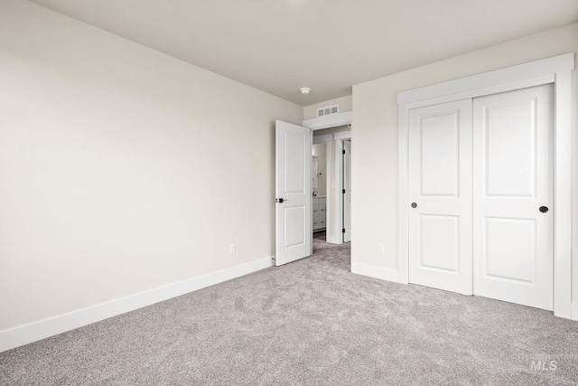 unfurnished bedroom with carpet, visible vents, a closet, and baseboards