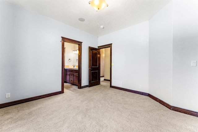 unfurnished room with visible vents, baseboards, and light colored carpet