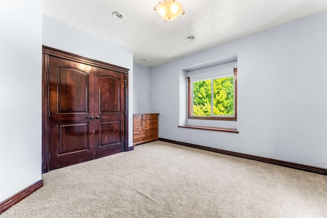 unfurnished bedroom with baseboards, visible vents, and light carpet