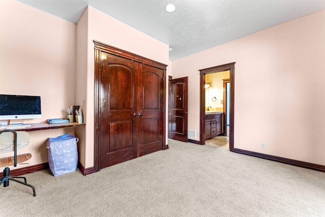 office area with baseboards, visible vents, and light carpet