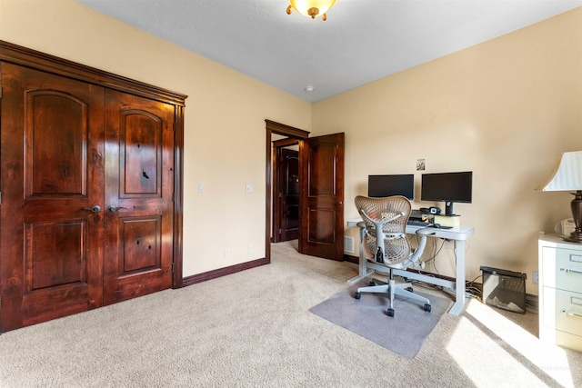 home office with baseboards and light carpet