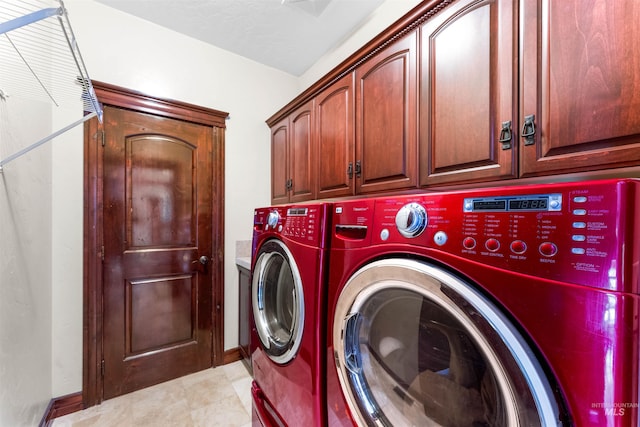 laundry area featuring cabinet space, light tile patterned floors, separate washer and dryer, and baseboards