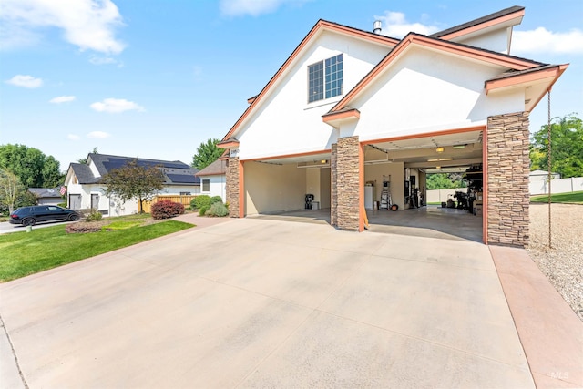 view of front facade with stone siding, stucco siding, driveway, and a front yard