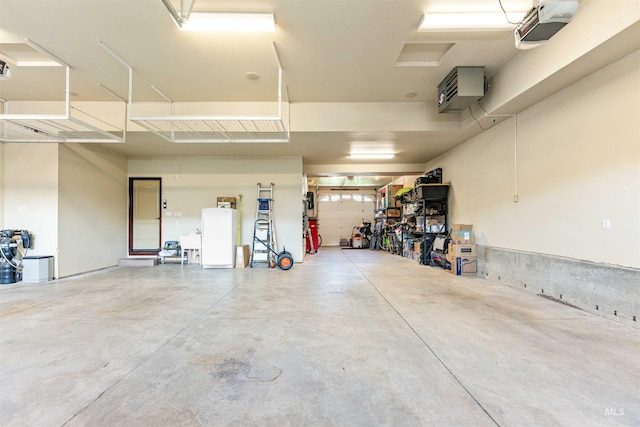 garage featuring a garage door opener, freestanding refrigerator, and a sink