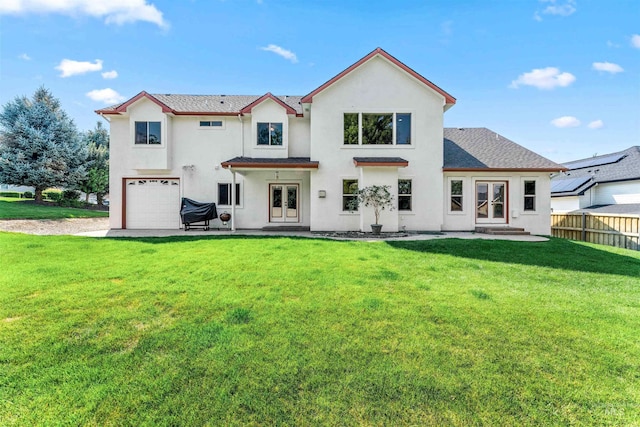 back of house with french doors, an attached garage, a yard, and fence