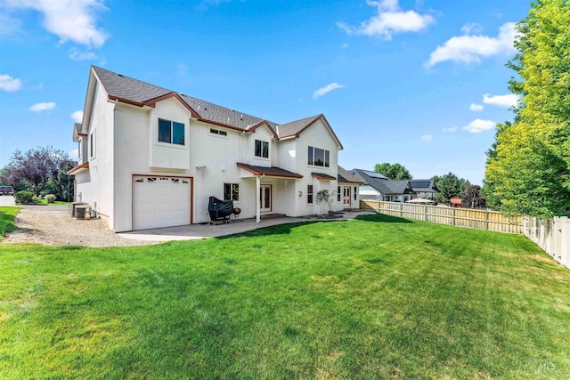 rear view of property with fence, central AC, stucco siding, a garage, and a lawn