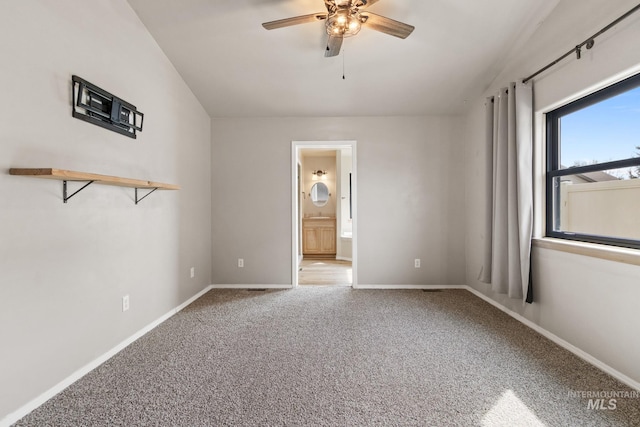 spare room with baseboards, a ceiling fan, and carpet
