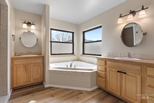 bathroom with a sink, two vanities, and wood finished floors
