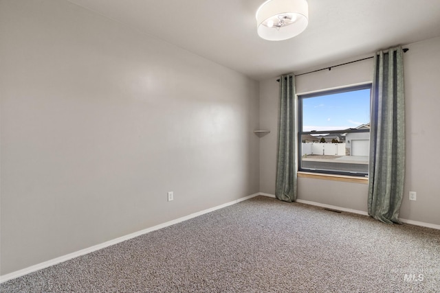 empty room featuring visible vents, baseboards, and light colored carpet