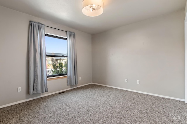 unfurnished room featuring baseboards, visible vents, and carpet floors