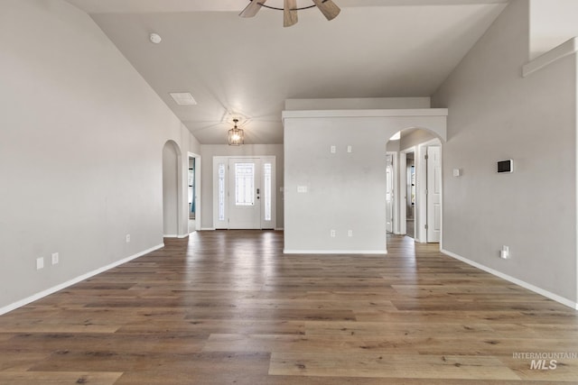 interior space with arched walkways, baseboards, and ceiling fan