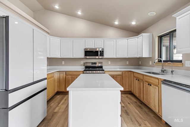 kitchen featuring stainless steel appliances, a center island, a sink, and lofted ceiling