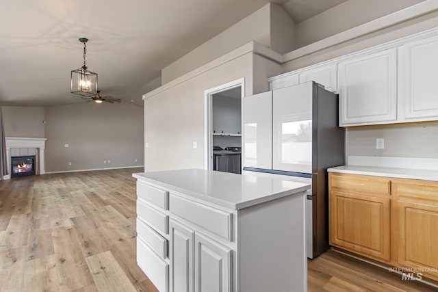 kitchen with separate washer and dryer, light countertops, freestanding refrigerator, and a kitchen island