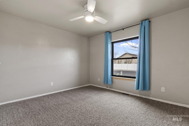 empty room with carpet flooring, visible vents, baseboards, and a ceiling fan