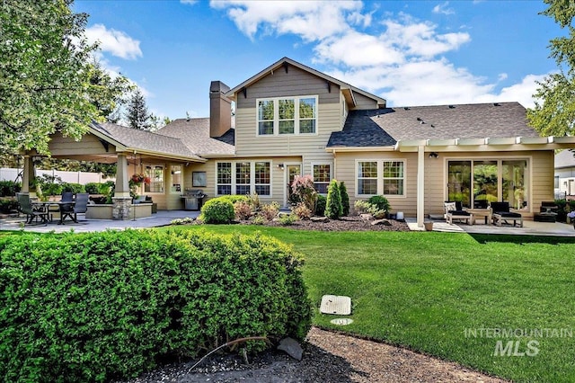 178 Cottonwood Ct, Eagle, ID 83616 - rear view of house with a yard, a patio area, a shingled roof, and a chimney