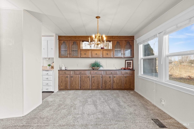 kitchen featuring carpet floors, an inviting chandelier, and decorative light fixtures