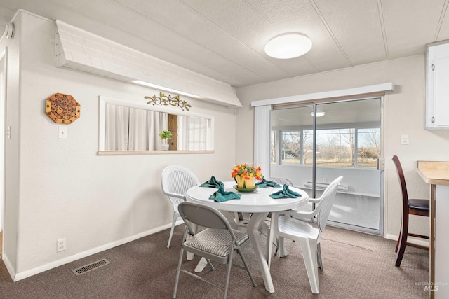 dining space with carpet floors and a textured ceiling