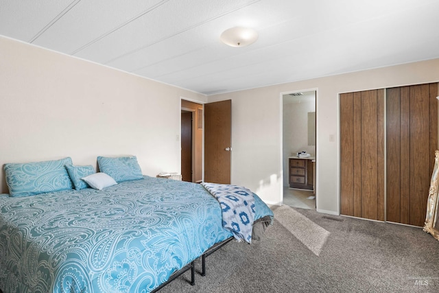 bedroom with ensuite bathroom and carpet flooring