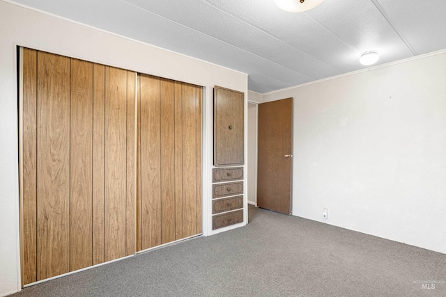 unfurnished bedroom featuring dark colored carpet and a closet