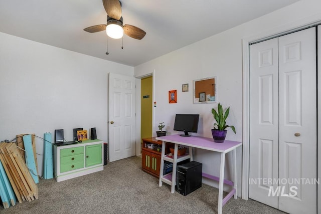 carpeted home office with a ceiling fan