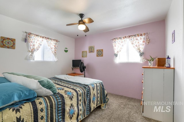 carpeted bedroom with a ceiling fan and multiple windows