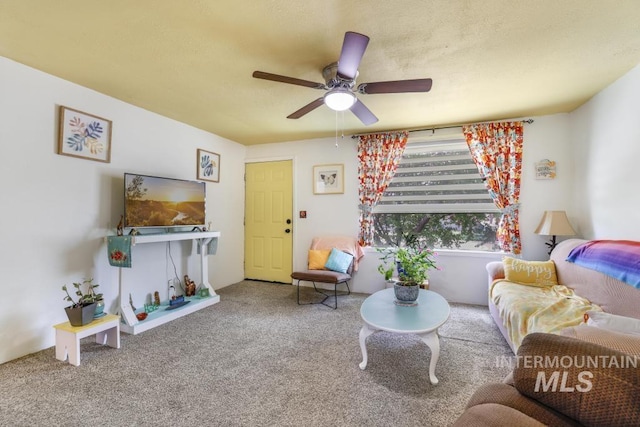 carpeted living area with a ceiling fan