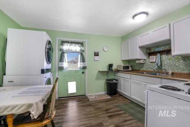 kitchen with backsplash, stacked washer / dryer, a sink, white appliances, and dark wood-type flooring