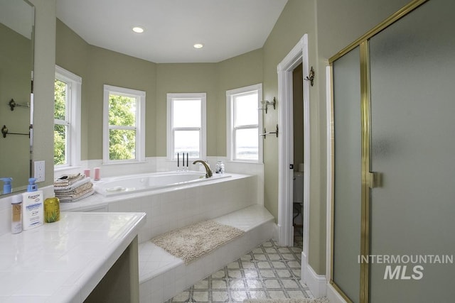 bathroom with a bath, a stall shower, and recessed lighting