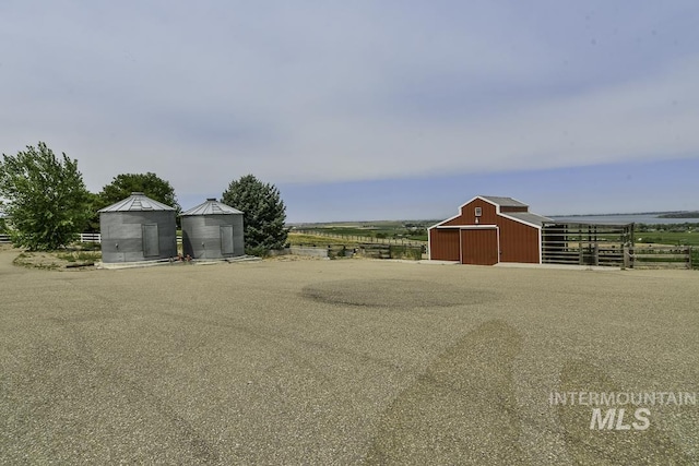 view of yard featuring a barn, fence, and an outbuilding