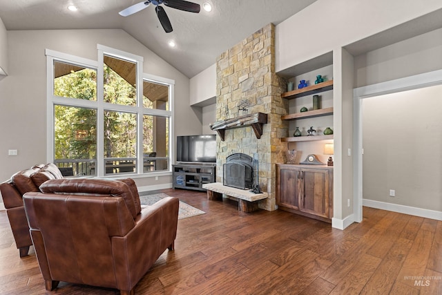 living room featuring ceiling fan, a textured ceiling, high vaulted ceiling, a fireplace, and dark hardwood / wood-style flooring