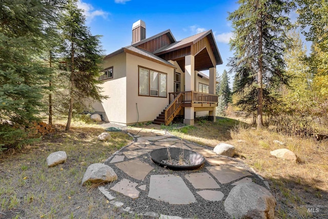 rear view of house with an outdoor fire pit