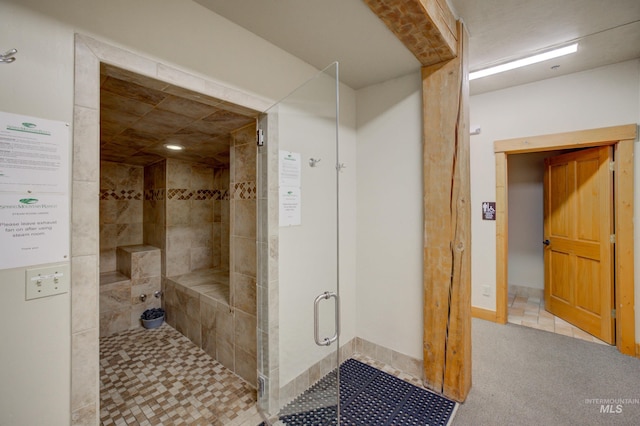 bathroom with a shower with shower door and tile patterned flooring