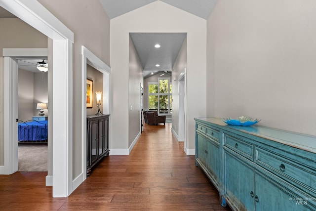 corridor with lofted ceiling and dark hardwood / wood-style flooring