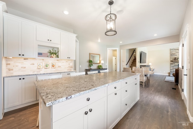 kitchen featuring white cabinets, dark wood finished floors, a kitchen island, backsplash, and recessed lighting