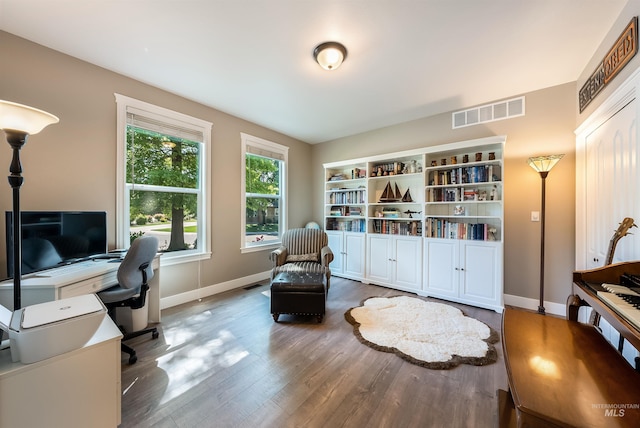 office area with visible vents, baseboards, and wood finished floors