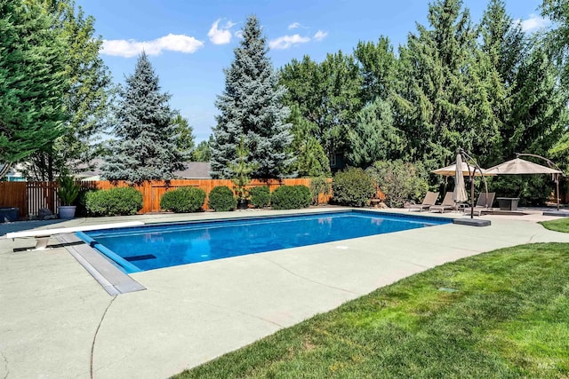 view of swimming pool with a lawn, a patio area, fence, and a fenced in pool