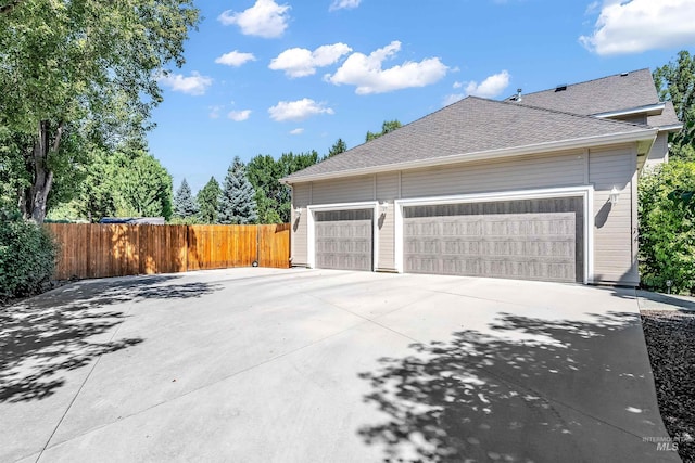 garage with driveway and fence