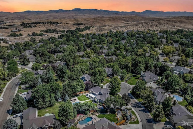 aerial view at dusk featuring a residential view and a mountain view