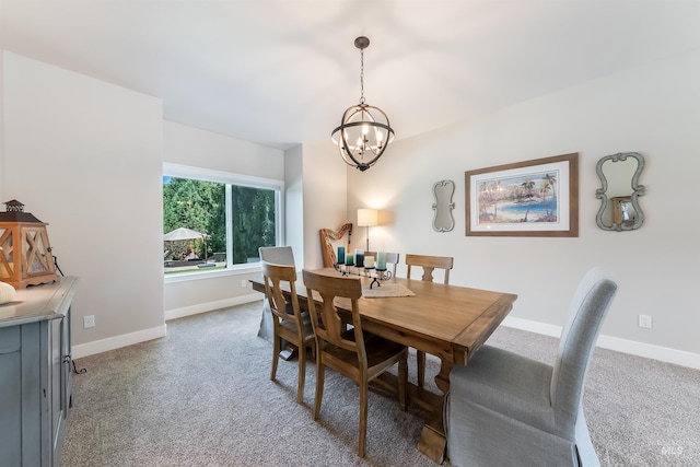 dining room featuring light carpet, a chandelier, and baseboards