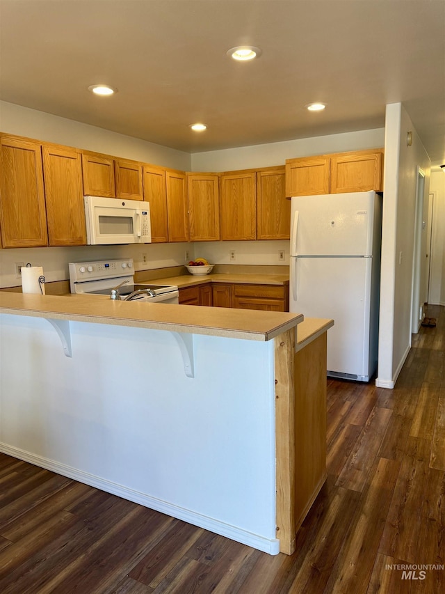 1425 Clements, Mccall, ID 83638 - kitchen featuring white appliances, a peninsula, light countertops, a kitchen bar, and recessed lighting